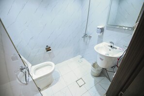 Ein Badezimmer mit Toilette, Waschbecken und Dusche.