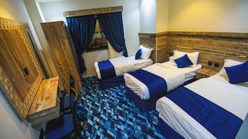 Habitación de hotel con dos camas, un escritorio y un espejo.