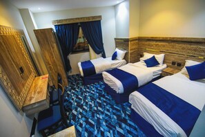 Ein Hotelzimmer mit zwei Betten, einem Schreibtisch und einem Spiegel.
