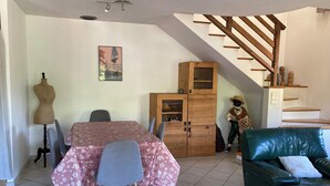 A dining area with a table and chairs, a mannequin, a cabinet, and a staircase. - Apartment near the lake with a terrace offering mountain views. (Doussard)