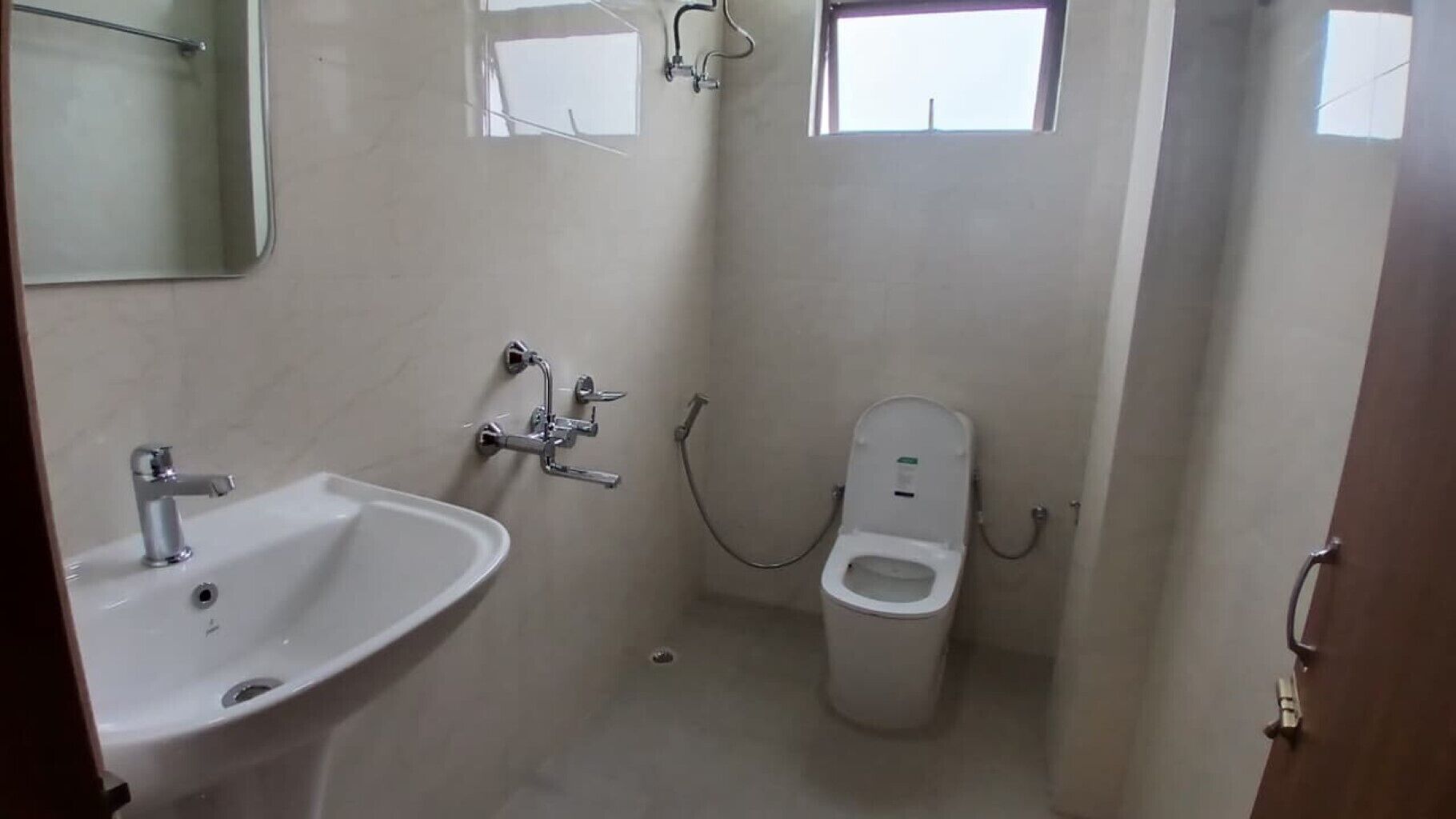 A small, compact bathroom with a sink, toilet, and shower.