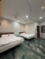 A hotel room with two beds, a ceiling fan, recessed lighting, and a marble floor.