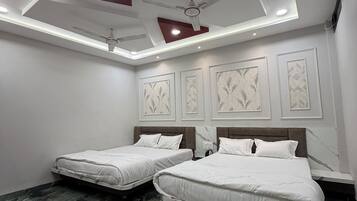 A hotel room with two beds, a ceiling fan, recessed lighting, and a marble floor.
