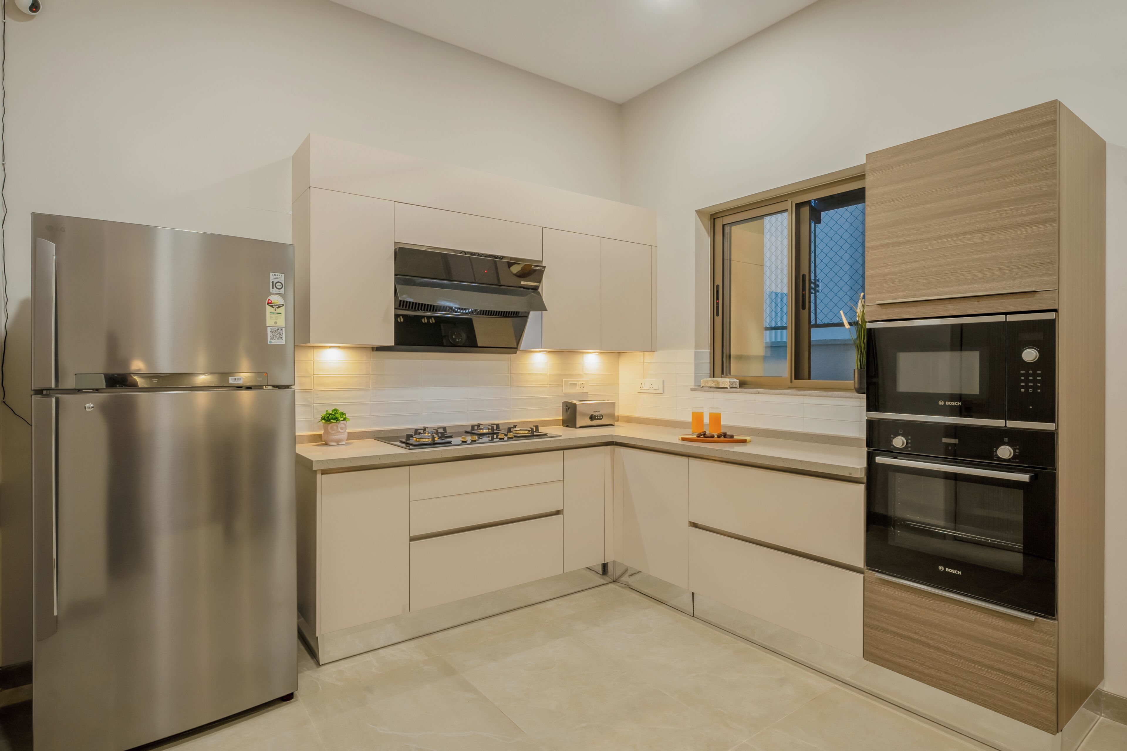 Una cocina moderna con electrodomésticos de acero inoxidable, horno empotrado y ventana con vistas.