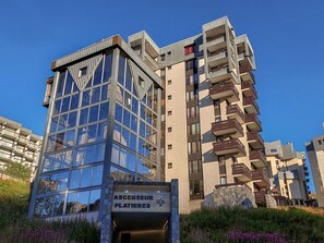A modern building with a glass facade and multiple balconies. - Les Grandes Platières (Val Claret) by Interhome (Tignes)