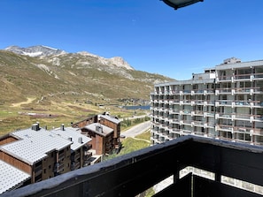A multi-story hotel with balconies, a view of a mountainous landscape, and a body of water in the distance. - Les Grandes Platières (Val Claret) by Interhome (Tignes)