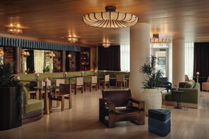 A spacious lobby with a high ceiling, wooden flooring, and a variety of seating options including sofas, chairs, and a bar area. - 4BDR South Lamar Stay w/ Pool, Rooftop, Restaurant | The Code by AvantStay (Austin)