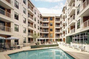 A modern multi-story hotel with balconies, a swimming pool, and outdoor seating areas. - 4BDR South Lamar Stay w/ Pool, Rooftop, Restaurant | The Code by AvantStay (Austin)