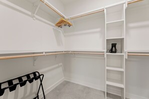 A walk-in closet with open shelving, a hanging rod, and a shoe rack. - 4BDR South Lamar Stay w/ Pool, Rooftop, Restaurant | The Code by AvantStay (Austin)