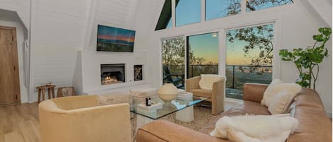 Vaulted living room with floor-to-ceiling windows and plush seating.
