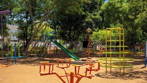 A playground with various play structures including swings, slides, and climbing frames.