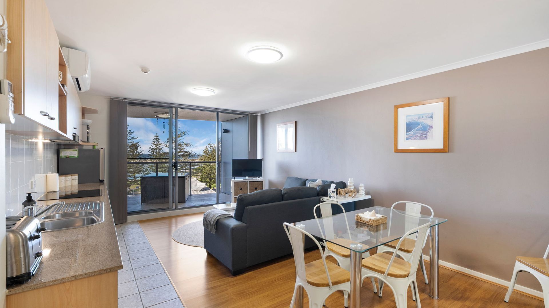 A modern apartment with a balcony, a dining area, and a kitchen.