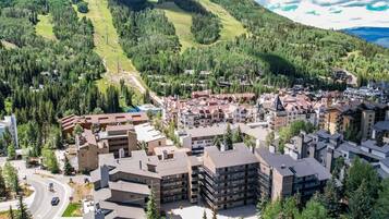 Un quartier résidentiel composé d’immeubles à plusieurs étages, de routes et bordé par des montagnes.