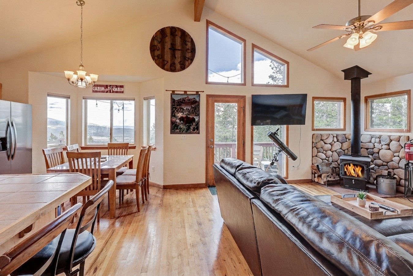 A spacious living room with a fireplace, a television, and a large window overlooking a scenic landscape.
