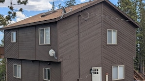Ein zweistöckiges Gebäude mit brauner Fassade, einer Satellitenschüssel und einem Willkommensschild.