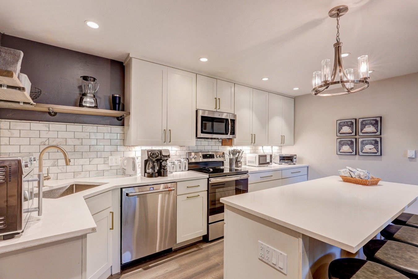 A modern kitchen with stainless steel appliances, white cabinetry, and a central island.