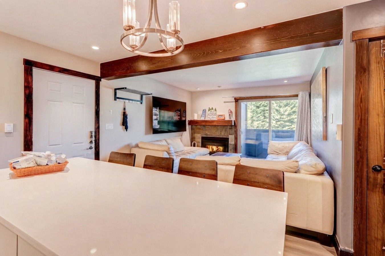 A modern kitchen with a large island, a dining area with a sofa, and a fireplace.