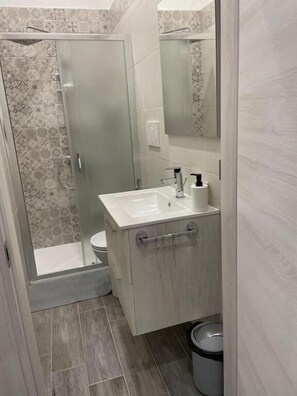A bathroom with a shower, toilet, and sink. - Affitti brevi Poesia (Taranto)