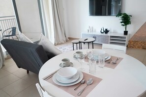 A dining area with a round table set for two, white plates, clear glasses, and cutlery. - Burj Views Studio - Downtown Dubai -Bills Included (Dubai)