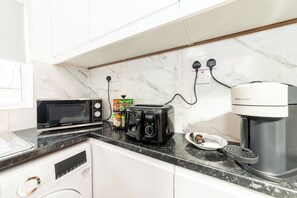 A kitchen with a microwave, toaster, coffee maker, and a dish rack. - Spacious 5-Bedroom House in Berkshire - Perfect Family Retreat (Berkshire)