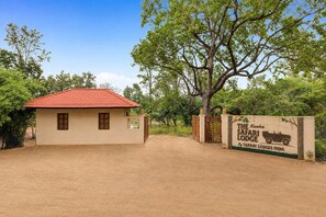 A safari lodge entrance with a brick building and a red-tiled roof.