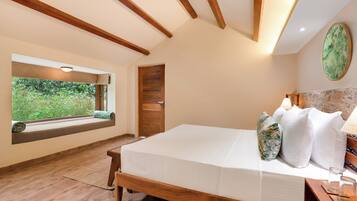 Un dormitorio con cama de madera, ventana con vista a follaje y pared de piedra decorativa.