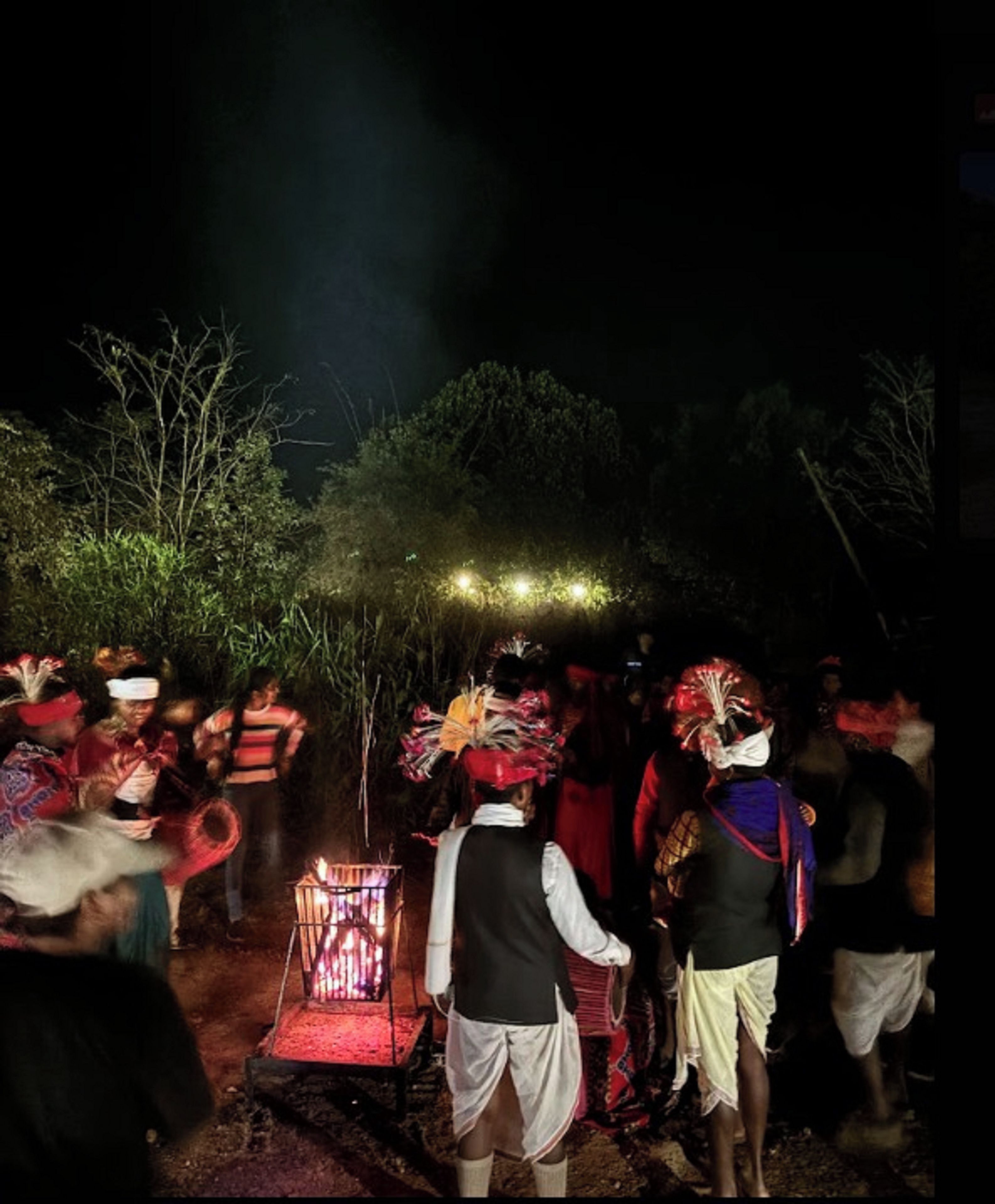 Un groupe de personnes s’est rassemblé autour d’un foyer au milieu de la nuit.