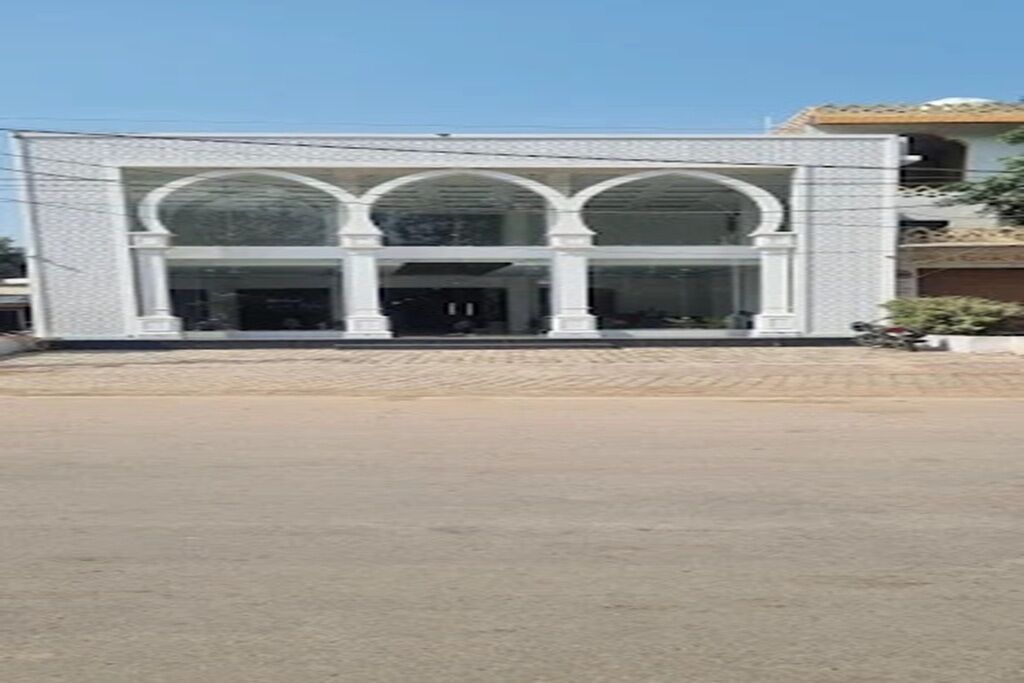 Un edificio con fachada simétrica, amplias ventanas de arco y una entrada central.