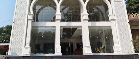 A building with a symmetrical facade, large glass windows, and a central entrance with a decorative arch.