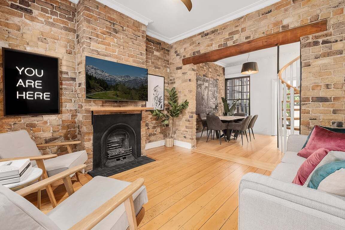 Ein Wohnzimmer mit Kamin, einem an der Wand montierten Fernseher und einem Essbereich mit Tisch und Stühlen.