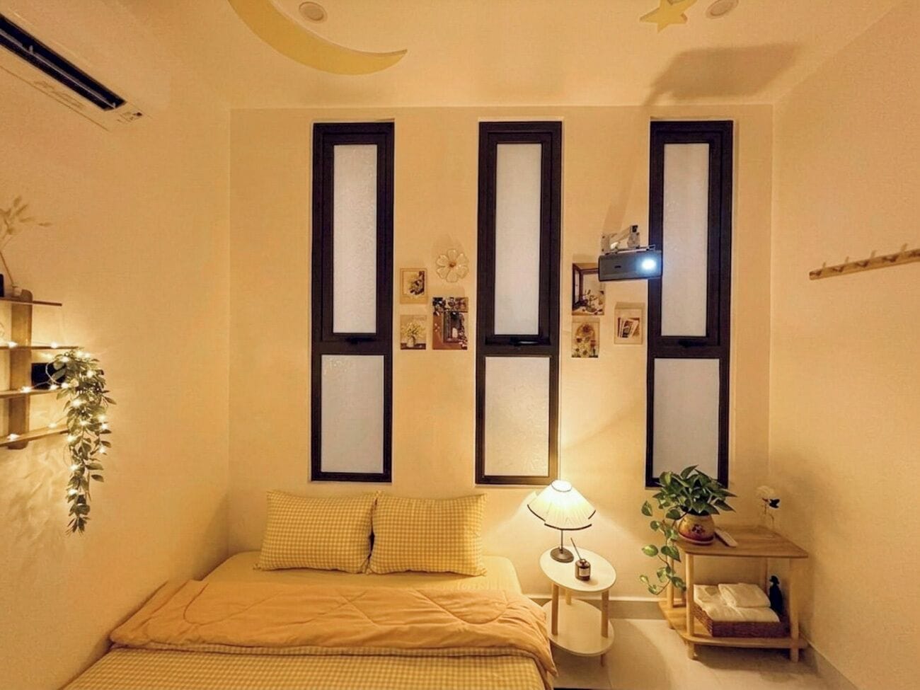 A bedroom with a bed, bedside table, lamp, and wall-mounted decorations.