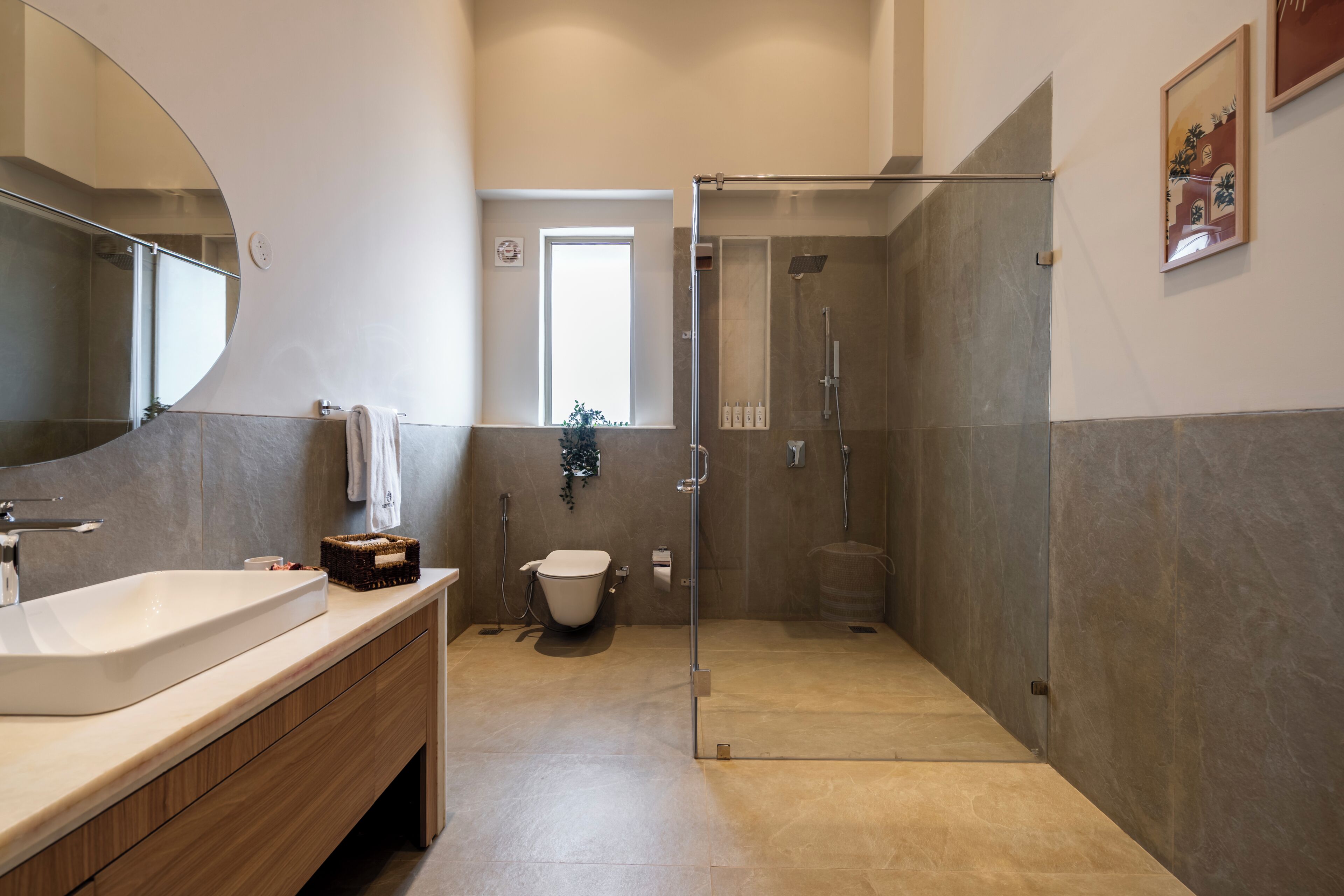A modern bathroom with a glass-enclosed shower, a white sink, and a wooden vanity.