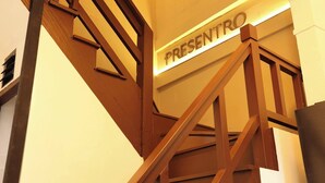 Eine Treppe mit einem Schild, auf dem 'PRESENTO' steht, die zu einer oberen Ebene führt.