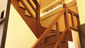 A staircase with a sign reading 'PRESENTO' leading to an upper level.