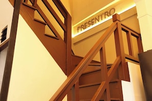 Eine Treppe mit einem Schild, auf dem 'PRESENTO' steht, die zu einer oberen Ebene führt.