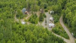 A forested area with a house and two yurts. - A tranquil yurt with all the amenities in charming Big Lake (Big Lake)