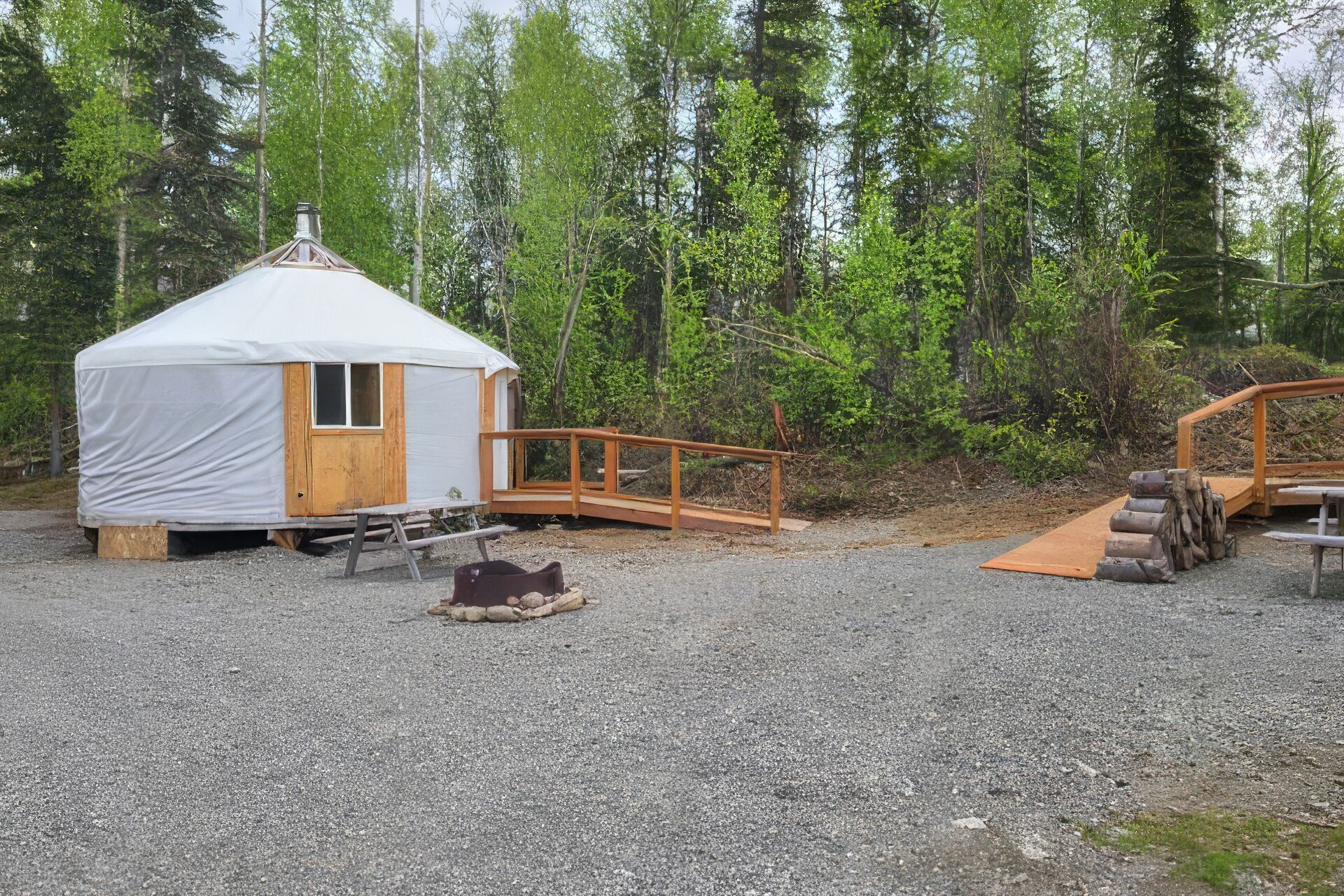 A small, covered structure with a wooden door and a ramp leading to a wooden platform.