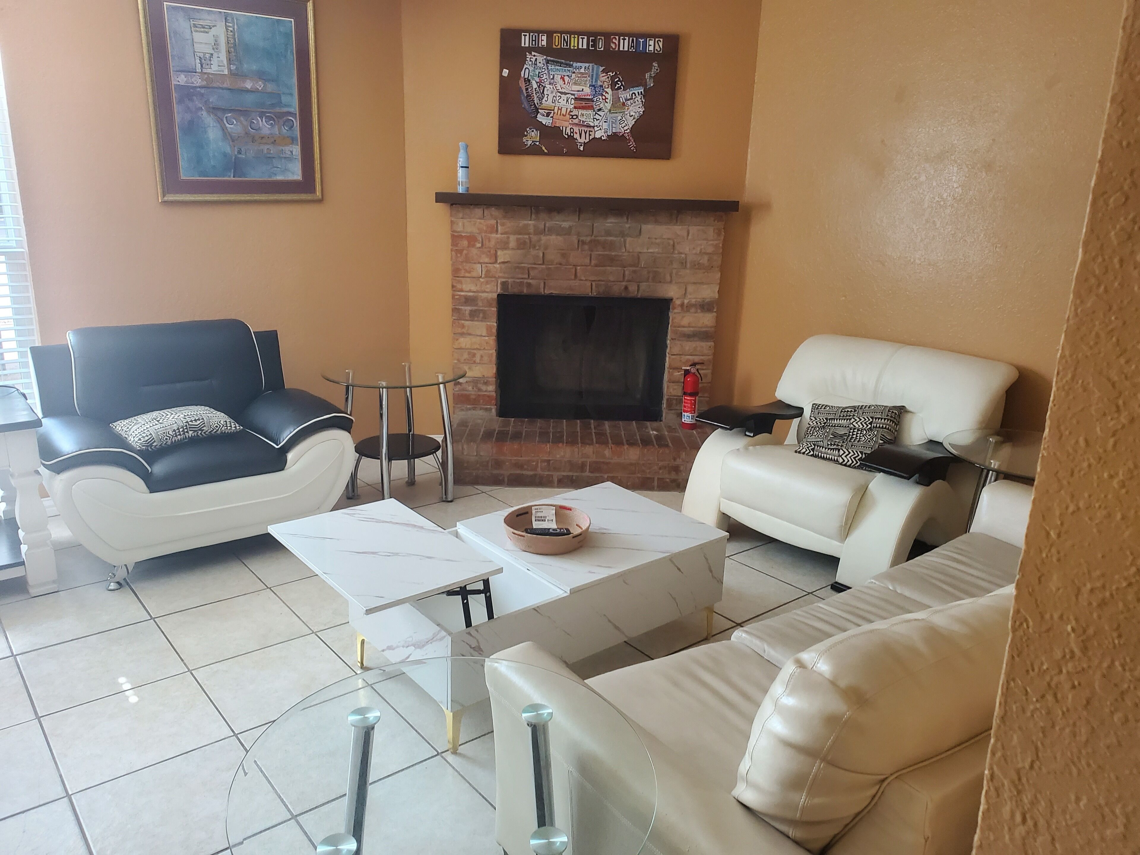 A living room with a fireplace, two sofas, a coffee table, and a small side table.
