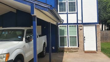 A two-story building with a garage and a white pickup truck parked in front.