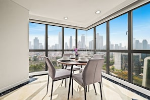 Ein Essbereich mit Blick auf die Stadt, ein runder Tisch und vier Stühle.