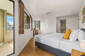 Ein modernes Hotelzimmer mit einem großen Bett, einem Schreibtisch und Blick auf die Stadt.