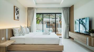 A modern hotel room with a large bed, a TV, and a view of the pool area.
