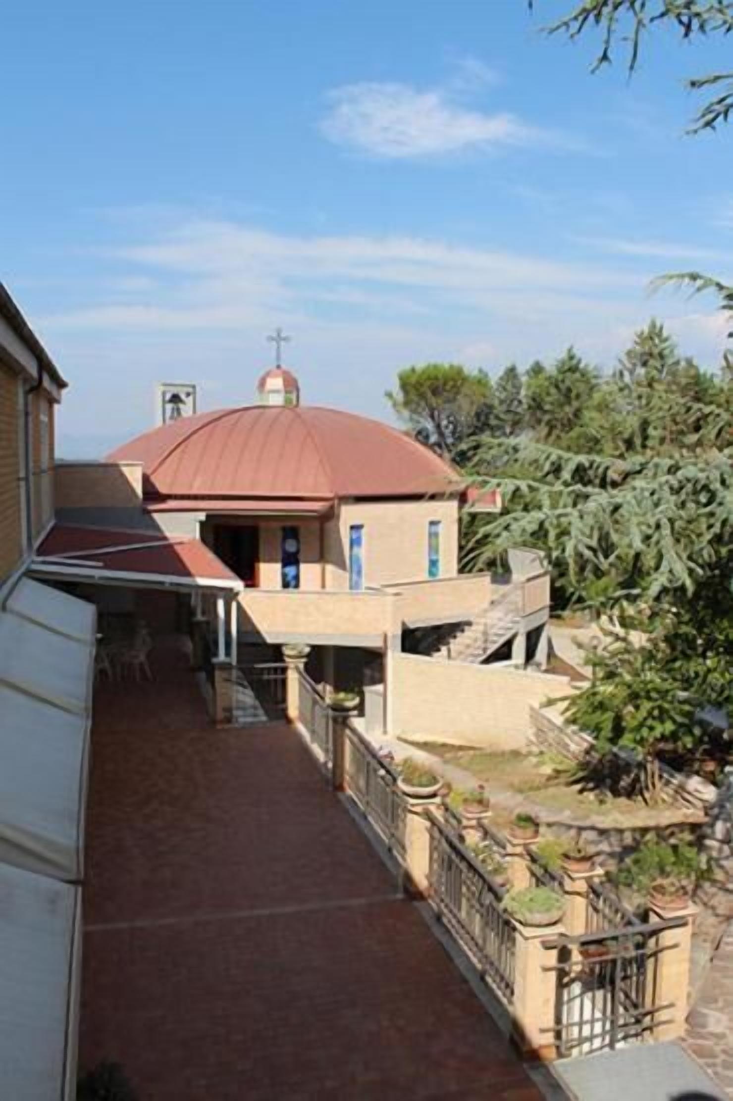 A residential building with a red dome, a balcony, and a gated entrance.
