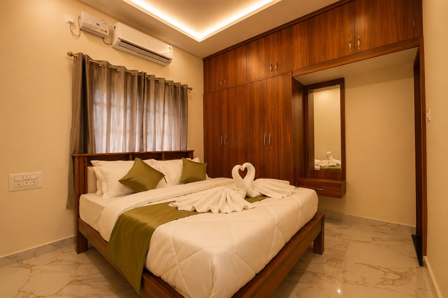 Ein Hotelzimmer mit Bett, Holzschrank und Spiegel.