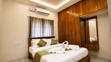 Quarto de hotel com cama, espelho, guarda-roupa de madeira e aparelho de ar condicionado.