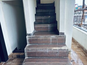 A set of dark wooden stairs with white trim leading to an upper floor. - Hotel Jhansi Grand Inn (Jhansi)