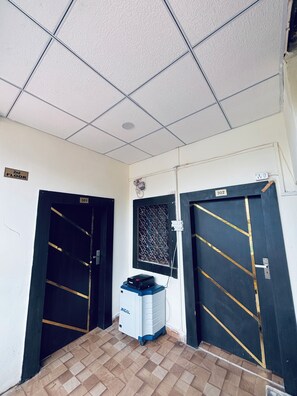 Un pasillo con dos puertas, una identificada con '301' y la otra con '302', y una unidad de aire acondicionado Jindal en el centro.