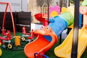 A children's play area with various colorful slides and play structures.