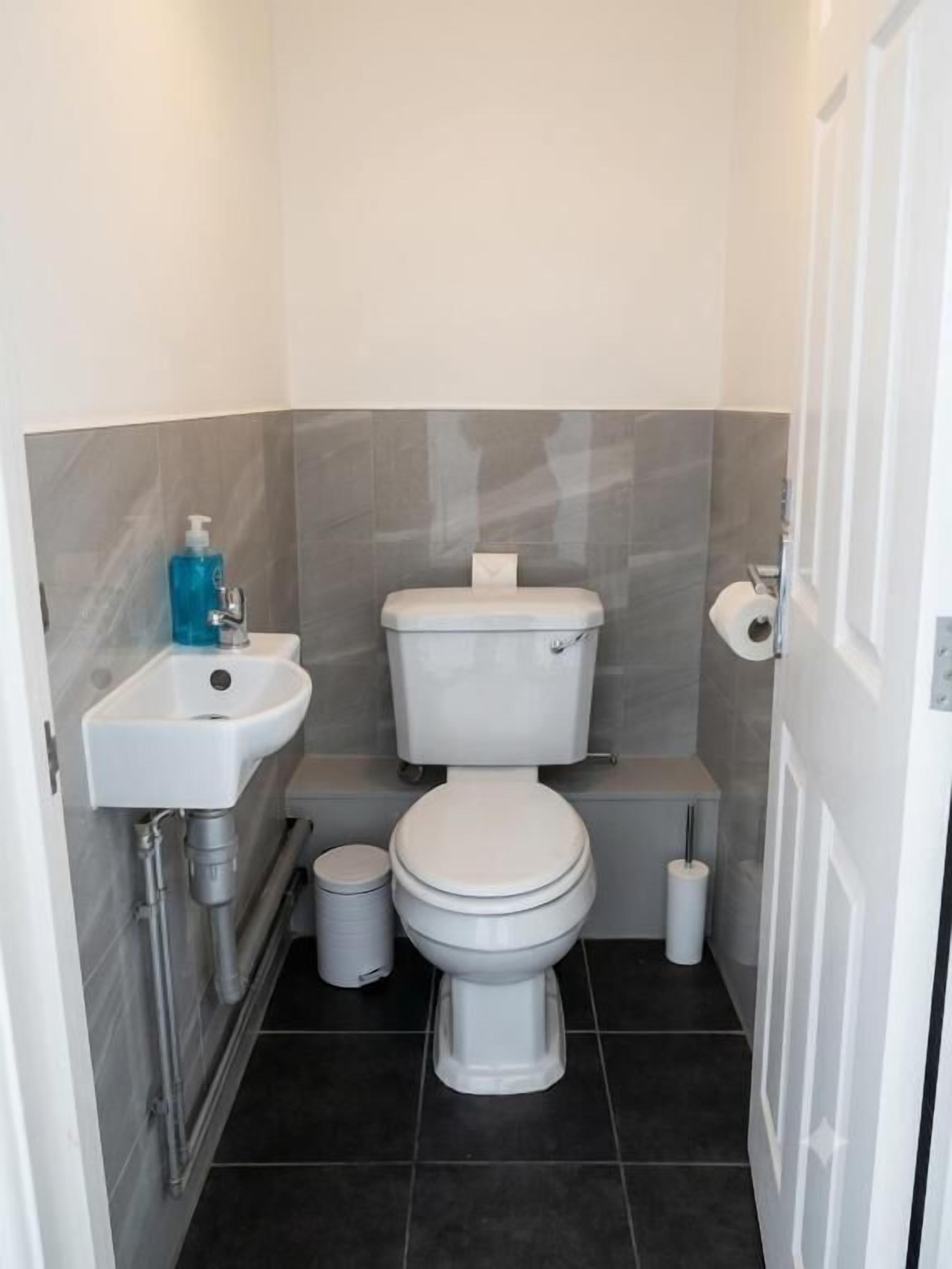 Une petite salle de bain avec des toilettes, un lavabo et une poubelle.