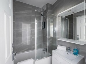 A modern bathroom with a glass-enclosed shower, a white sink, and a large mirror. - Brigstock Luxe Stay Modern 2-Bed Apartment (Thornton Heath)